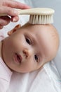 Mother combing or brushing her little cute baby girl after bathing. Maternity Love Care Concept. Royalty Free Stock Photo