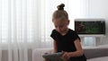 Mother combs cute daughter hair, which looks at tablet. Mother spends time with daughter