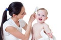 Mother combing kid's hair after bathing baby