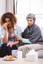 Mother comforting crying daughter sitting on sofa Royalty Free Stock Photo