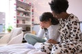 Mother Comforting Teenage Daughter In Bedroom Looking At Letter With Disappointing Exam Results Royalty Free Stock Photo