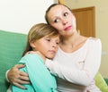 Mother consoling crying teenage son at home