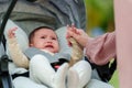 mother consoling her infant baby crying in stroller Royalty Free Stock Photo