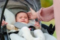 mother consoling her infant baby crying in stroller Royalty Free Stock Photo