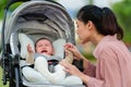 mother consoling her infant baby crying in stroller Royalty Free Stock Photo