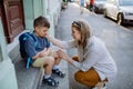 Mother consoling her little son on his first day of school,sitting on stairs and saying goodbye before school. Royalty Free Stock Photo