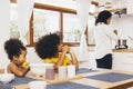 Mother cooking for her two children waiting for lunch. Single mom concept Royalty Free Stock Photo