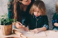 Mother cooking with kids in kitchen. Toddler siblings baking together and playing with pastry at home