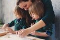 Mother cooking with kids in kitchen. Toddler siblings baking together and playing with pastry at home