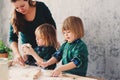 Mother cooking with kids in kitchen. Toddler siblings baking together and playing with pastry at home