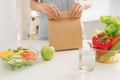 Mother cooking school lunch box set, Preparing healthy snacks - cheese sandwich, fruits and vegetable in paper bag Royalty Free Stock Photo