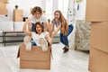 Mother and couple smiling confident transportating woman by cardboard box as a car at home Royalty Free Stock Photo