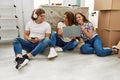 Mother and couple using smartphone and laptop sitting on the floor at home Royalty Free Stock Photo