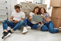 Mother and couple using smartphone and laptop sitting on the floor at home Royalty Free Stock Photo