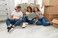 Mother and couple using smartphone and laptop sitting on the floor at home Royalty Free Stock Photo