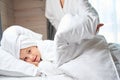 Mother covering her pretty sweet daughter in bathrobe with warm blanket Royalty Free Stock Photo