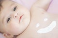 Cute baby with body cream on tummy. Mother creaming Royalty Free Stock Photo