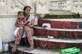 Mother cuddling baby son at church yard patio selling candles