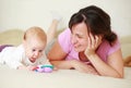 Mother with cute baby on bed