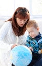 Mother and cute kid studying globe together Royalty Free Stock Photo