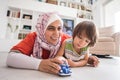 Mother and cute son playing with car toy