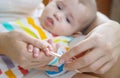 mother cuts little baby's nails. Selective focus.