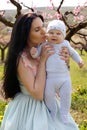 Mother with dark hair in elegant dress posing with her little cu Royalty Free Stock Photo