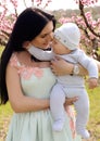 Mother with dark hair in elegant dress posing with her little cu Royalty Free Stock Photo