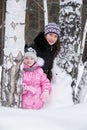 Mother and daughte, winter in the snow trees