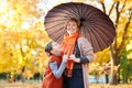 Mother and daughter are in autumn city park. Peoples are posing under umbrella. Children and parents are smiling, playing and havi Royalty Free Stock Photo