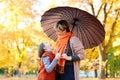 Mother and daughter are in autumn city park. Peoples are posing under umbrella. Children and parents are smiling, playing and havi Royalty Free Stock Photo