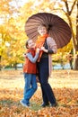 Mother and daughter are in autumn city park. Peoples are posing under umbrella. Children and parents are smiling, playing and havi Royalty Free Stock Photo