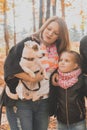 Mother and daughter in autumn park, girl hugging her jack russell terrier dog. Generations, pet and family concept. Royalty Free Stock Photo