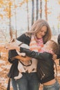 Mother and daughter in autumn park, girl hugging her jack russell terrier dog. Generations, pet and family concept. Royalty Free Stock Photo