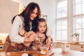 Mother and daughter baking Christmas biscuits on kitchen at home. Little girl whisking eggs helping mom with cooking Royalty Free Stock Photo