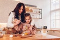 Mother and daughter baking Christmas biscuits on kitchen at home. Little girl whisking eggs helping mom with cooking Royalty Free Stock Photo