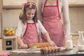 Little girl using a rolling pin in the kitchen