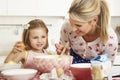 Mother And Daughter Baking In Kitchen