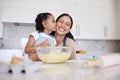 Mother and daughter baking together in a home kitchen. Caring small adorable little girl kissing her single mother on Royalty Free Stock Photo