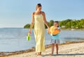 Mother and daughter with ball walking along beach Royalty Free Stock Photo