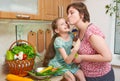 Mother and daughter with basket of vegetables and fresh fruits in kitchen interior. Parent and child. Healthy food concept Royalty Free Stock Photo