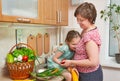 Mother and daughter with basket of vegetables and fresh fruits in kitchen interior. Parent and child. Healthy food concept Royalty Free Stock Photo