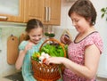 Mother and daughter with basket of vegetables and fresh fruits in kitchen interior. Parent and child. Healthy food concept Royalty Free Stock Photo