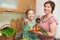 Mother and daughter with basket of vegetables and fresh fruits in kitchen interior. Parent and child. Healthy food concept Royalty Free Stock Photo