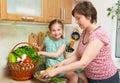 Mother and daughter with basket of vegetables and fresh fruits in kitchen interior. Parent and child. Healthy food concept Royalty Free Stock Photo