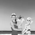 Mother and daughter on beach holding windmill toy Royalty Free Stock Photo