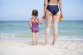 Mother daughter beach together rear view Unrecognizable caucasian woman little girl swimwear standing seaside back