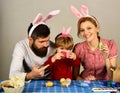 Mother, daughter and bearded father with happy faces painting eggs Royalty Free Stock Photo