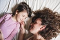 Mother and daughter in bed look at each other tenderly Royalty Free Stock Photo