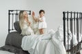 Mother and daughter in bed in the morning, happy mother plays with child clapping her hands Royalty Free Stock Photo